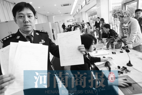 　民警左手拿的是新申請表，右手拿的是三份老申請表 王春勝/攝