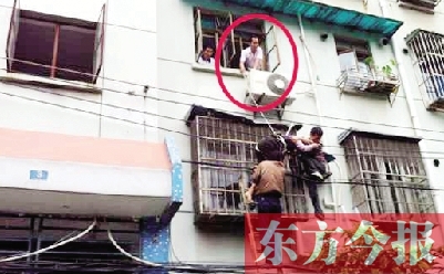 施救現(xiàn)場，劉鵬（圈內(nèi)）先用繩子捆住老太確保安全 勞動報(bào)記者 郭娜 供圖