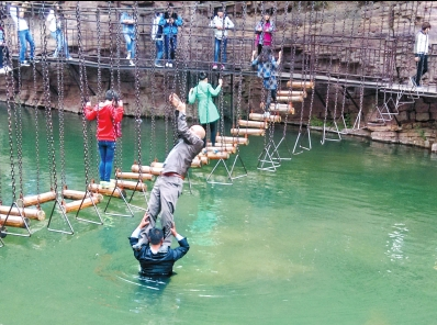 中年男游客正踩著景區(qū)安全員郭小明的肩膀過河。網(wǎng)友“@我的小名叫張孩”供圖