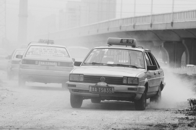 施工的道路上，車輛通過塵土飛揚。