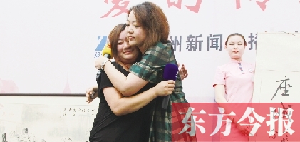 最終競(jìng)拍成功的盧女士與李剛妻子(左一)相擁在一起 最終競(jìng)拍成功的盧女士與李剛妻子(左一)相擁在一起