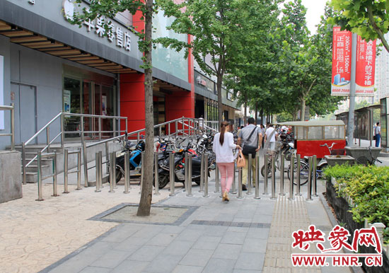 圖中道路左側(cè)的無障礙通道被鋼管隔離,右側(cè)的盲道也被侵占。