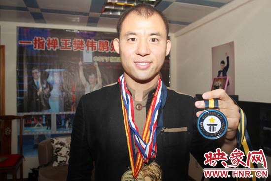 樊偉鵬向大家展示自己剛獲得的吉尼斯獎(jiǎng)牌。
