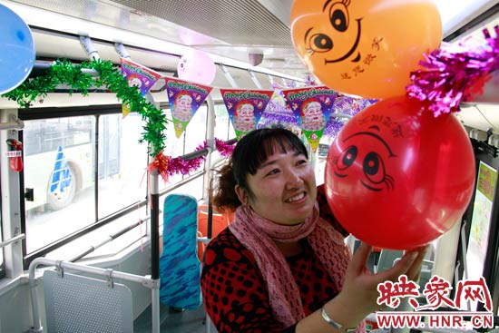 鄭州快速公交B3區(qū)間線車長(zhǎng)李鵬云在車廂里懸掛氣球，布置圣誕車廂，營(yíng)造歡樂圣誕氛圍