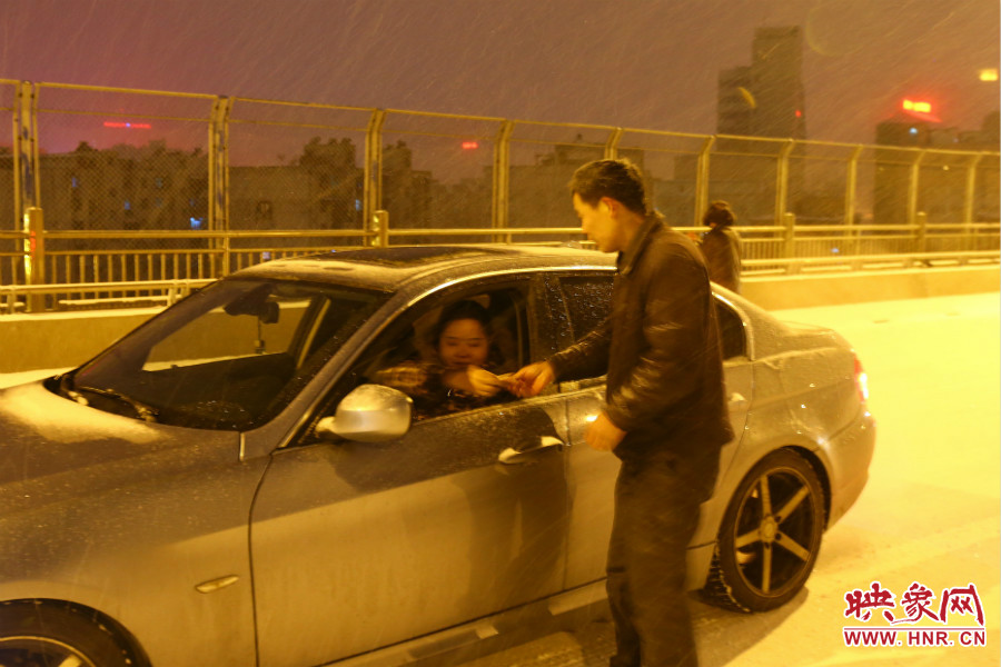 “推車人”幫助一輛車上坡后，收取“勞務(wù)費(fèi)”。