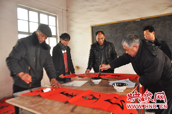 鞏義市魯莊鎮(zhèn)農(nóng)民書法愛(ài)好者正在寫春聯(lián)。