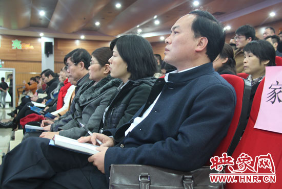 認(rèn)真聽取招生政策的學(xué)生家長。