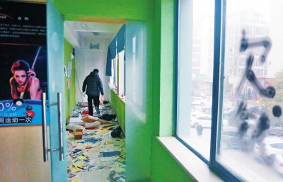 　健身會所地上一片狼藉，玻璃上噴著黑色“欠錢”二字。