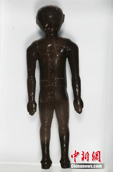 圖為出土的人體經(jīng)穴漆俑。