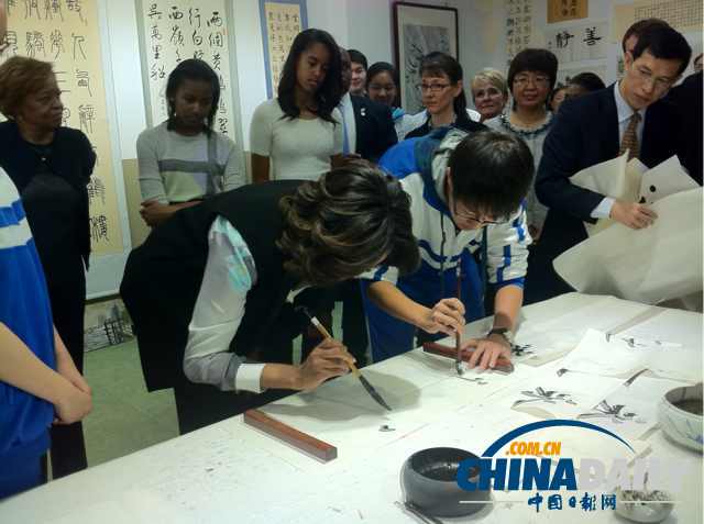 　北京時(shí)間3月21日，美國第一夫人米歇爾參觀北師大二附中時(shí)，與學(xué)生一起練習(xí)書法。