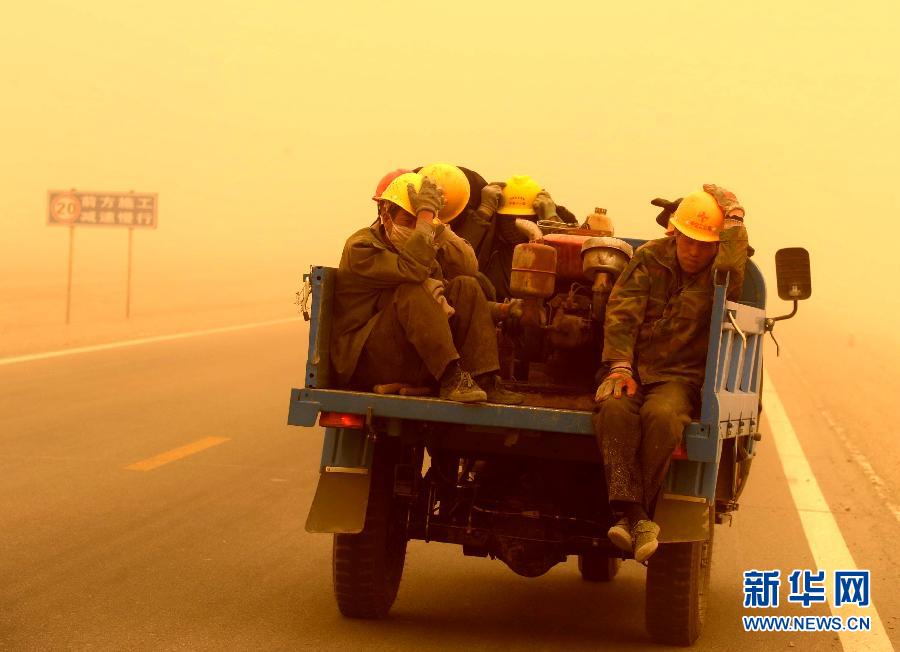 4月23日，一輛拉載公路施工人員的三輪車在沙塵暴中行駛在酒泉市瓜州縣城郊的公路上。