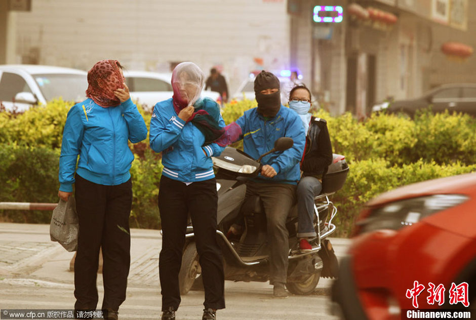 2014年04月23日，新疆維吾爾自治區(qū)吐魯番地區(qū)，市民戴著口罩行走在大風(fēng)沙塵中的吐魯番市街頭。