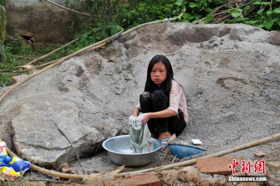 8月9日，云南巧家紅石巖村，10歲的劉鑫蕊在洗自己的衣服