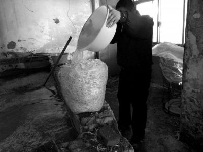 作坊內(nèi)工人用攪拌有漂白粉的藥水給豆芽增白。