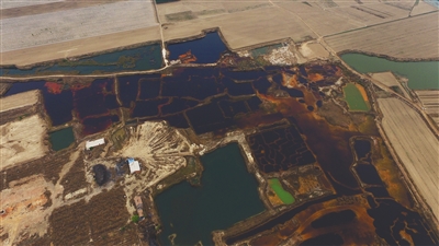 4月19日，廊坊市大城縣南趙扶鎮(zhèn)，津保路以北約八九百米處，一個(gè)巨大的污水坑中，水體呈現(xiàn)紅褐色。 新京報(bào)記者 尹亞飛 攝