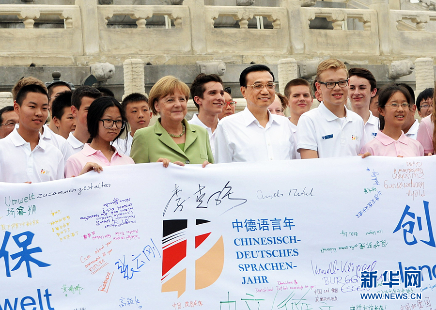 李克強(qiáng)同默克爾與青少年在天壇祈年殿前合影留念。