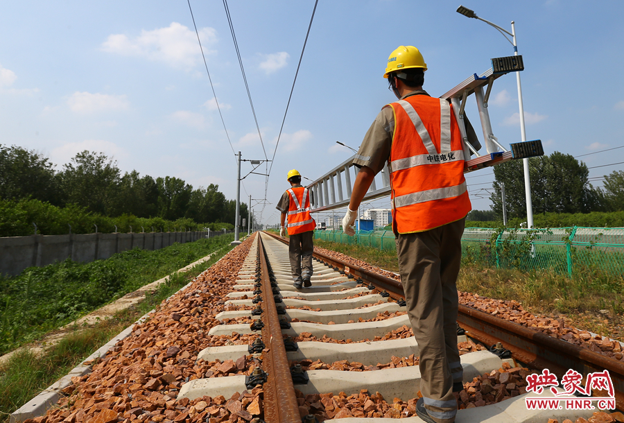 滾燙的鐵軌上，兩個(gè)扛著梯子的檢修員走向第四個(gè)檢修點(diǎn)