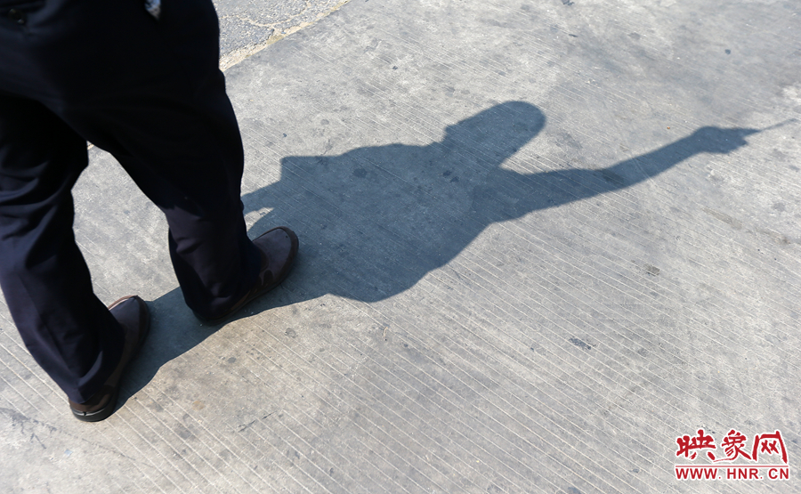 調度員指揮的身影映在炙熱的水泥地上