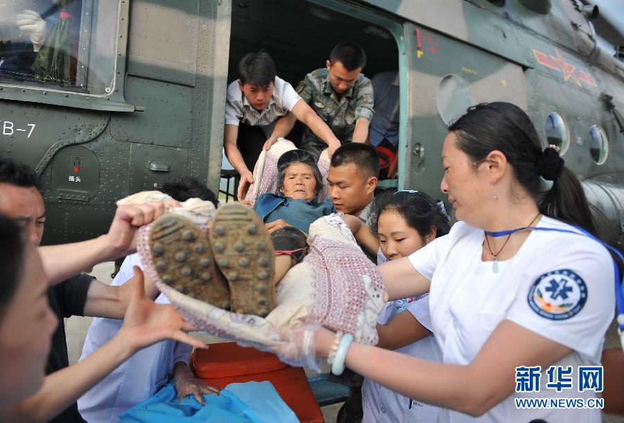 8月5日，醫(yī)護(hù)人員將一名通過直升機(jī)從震中轉(zhuǎn)運出來的傷員運下飛機(jī)。
