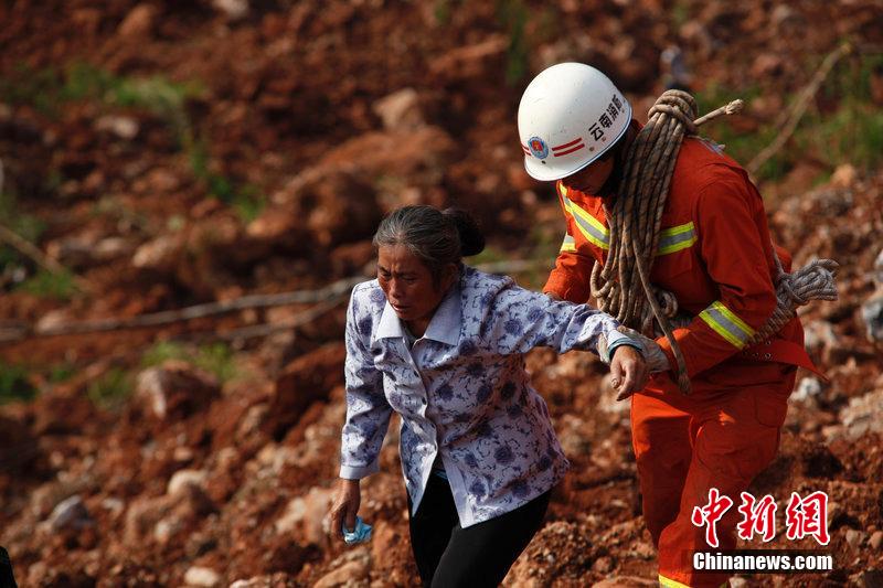 一位消防戰(zhàn)士將一位失去親人的老人扶離滑坡點(diǎn)。