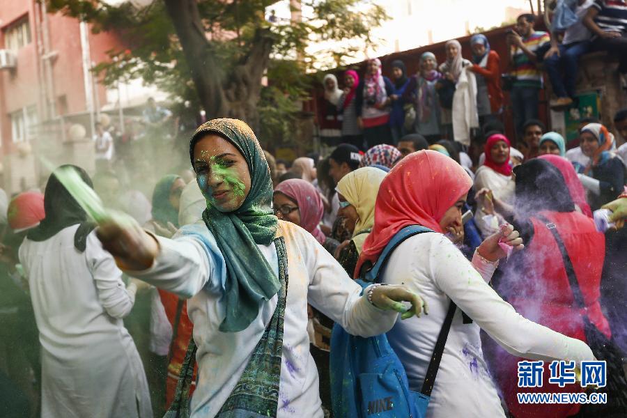 10月16日，在埃及首都開(kāi)羅，一名女青年在“彩色跑”活動(dòng)中拋撒彩色粉末。