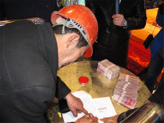 農(nóng)民工在現(xiàn)場(chǎng)領(lǐng)取工資。