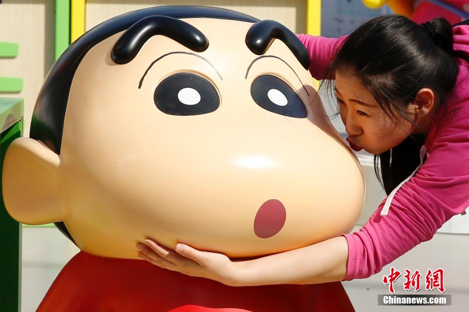 4月22日，游客與蠟筆小新合影?！跋灩P小新25周年紀(jì)念特展”日前在北京開(kāi)展，吸引了不少市民游客。