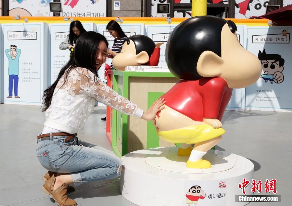 4月22日，游客與蠟筆小新合影?！跋灩P小新25周年紀(jì)念特展”日前在北京開(kāi)展，吸引了不少市民游客。