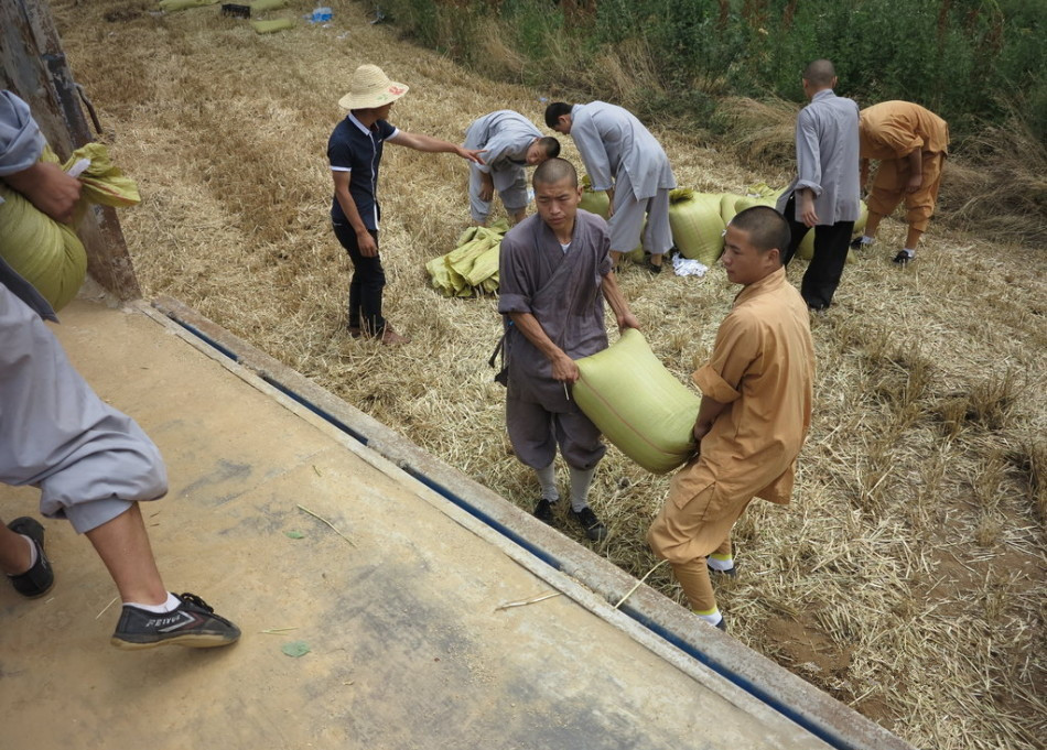 武僧將打包后的糧食集中至運(yùn)輸車輛上。
