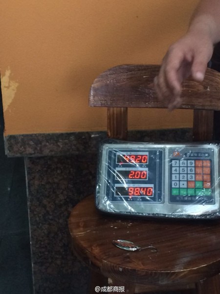 父子倆為大魚(yú)量體重。