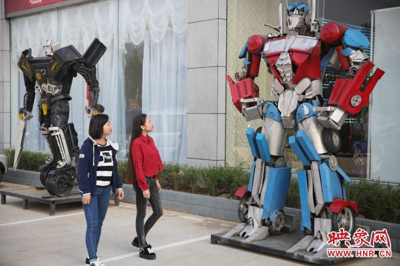 10月14日，市民在參觀河南省平頂山市寶豐縣一家企業(yè)門前的“變形金剛”。