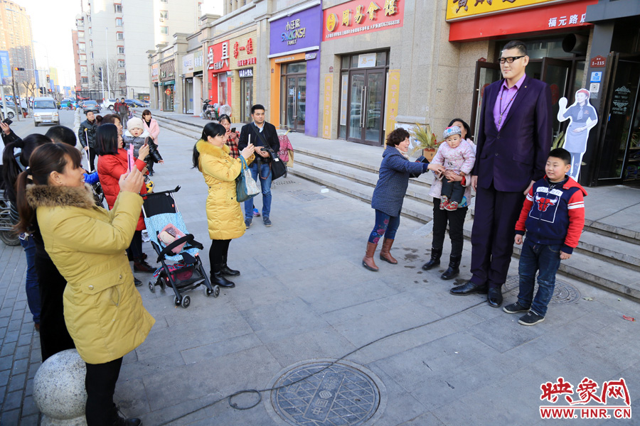 過(guò)路市民爭(zhēng)相與“巨人”合影。