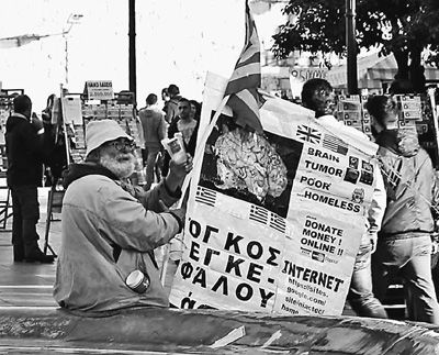 自債務(wù)危機(jī)爆發(fā)以來，希臘承諾實(shí)施以減薪、增稅、裁員和私有化為主要內(nèi)容的緊縮和改革政策。一系列的緊縮措施使民眾生活受到嚴(yán)重影響，約1/4的家庭陷入貧困。圖為今年1月希臘大選期間，在雅典市中心國會大廈前廣場乞討的老人。