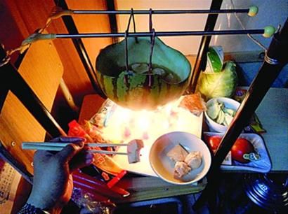 兩張椅子被面對面疊在一起，穿了兩根線的西瓜皮就懸空在椅腳中間，下面有蠟燭加熱，這就是西瓜火鍋。