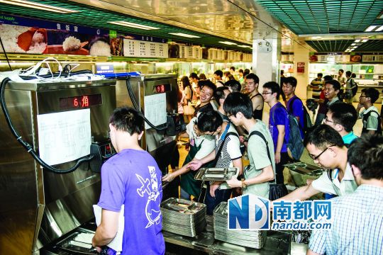昨日，華南理工大學(xué)一食堂內(nèi)，學(xué)生們正在使用新安裝的自動打飯機(jī)打飯。中新社發(fā)