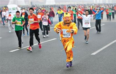 長(zhǎng)安街，一名打扮成孫悟空的參賽者在北馬隊(duì)伍里飛奔。 本版攝影/新京報(bào)記者 吳江 李飛 王嘉寧 吳江