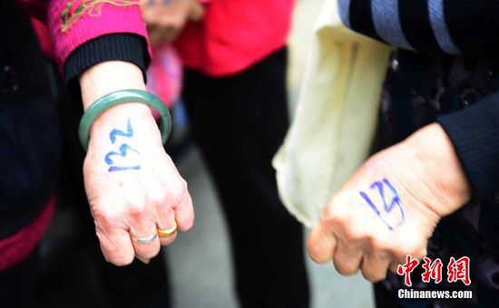 圖為10月28日，在江西九江市一家羊絨皮草服裝服飾博覽會(huì)現(xiàn)場(chǎng)，老人們正在頂著寒風(fēng)排隊(duì)等待領(lǐng)取10元代金劵。