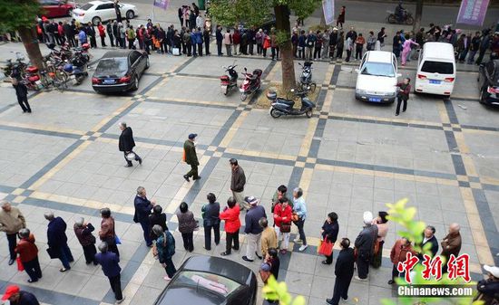 圖為10月28日，在江西九江市一家羊絨皮草服裝服飾博覽會(huì)現(xiàn)場(chǎng)，老人們正在頂著寒風(fēng)排隊(duì)等待領(lǐng)取10元代金劵。