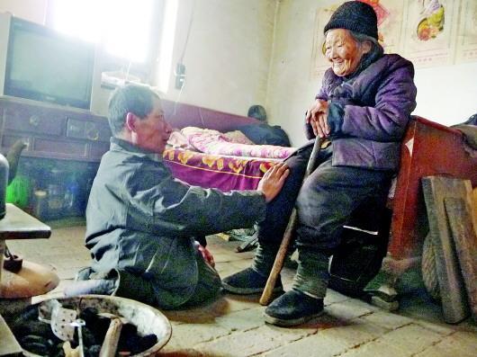 52歲的劉蘭山每天靠爬行照顧90歲的老母親。孫國祥 攝