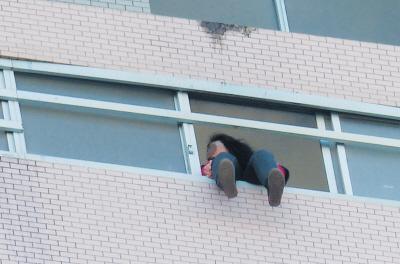 28樓的窗臺上坐著一名女子，其兩條腿耷拉在室外，不停地擺動。