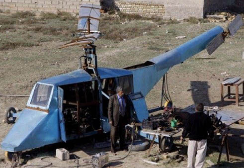 哈蒂姆·卡迪姆·薩爾曼正與工人交談，背后就是他正在制造的直升機(jī)