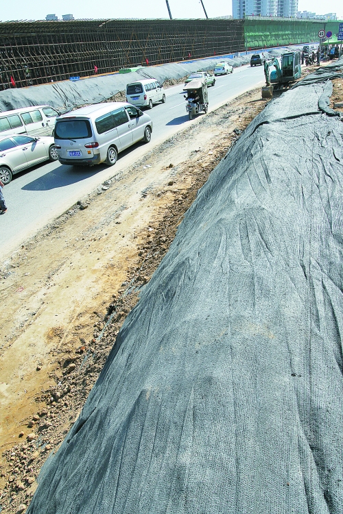 豐樂路與北三環(huán)交叉口，修路的土被歸置得整整齊齊，并用黑網(wǎng)覆蓋，既保暢通又避免了揚塵。