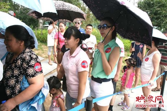 佩戴信息廣播臂貼的聽眾們在排隊(duì)等候坐帆船。