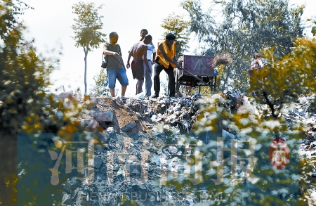 有人正在傾倒建筑垃圾，不遠(yuǎn)處就是村民的水井